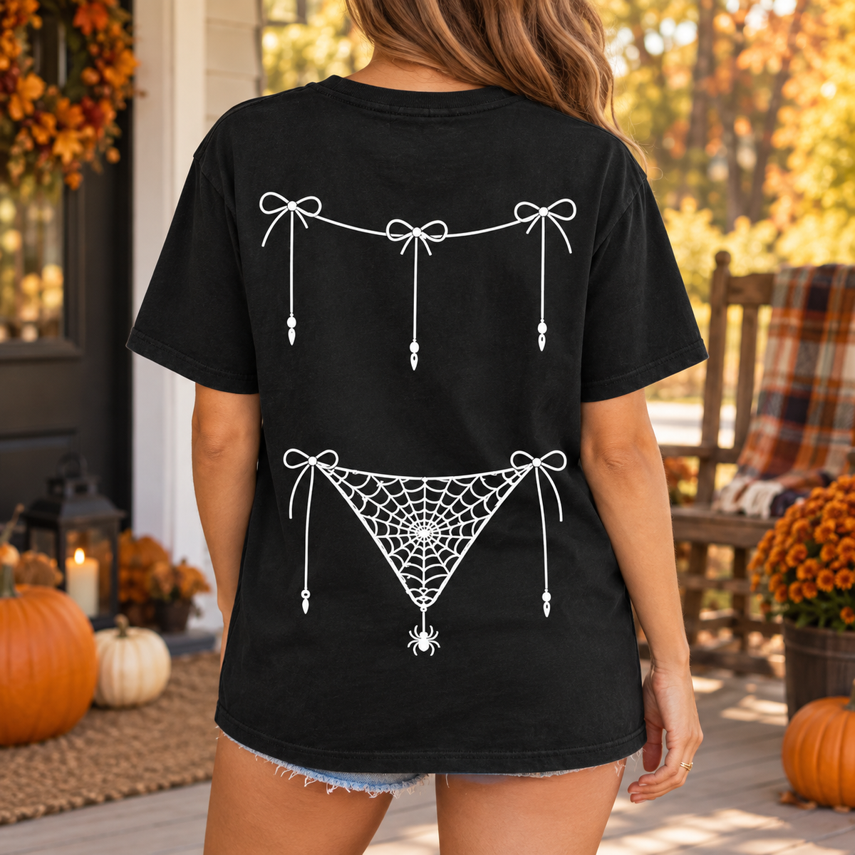 Back view of black Halloween shirt with coordinated bow and spider-web print